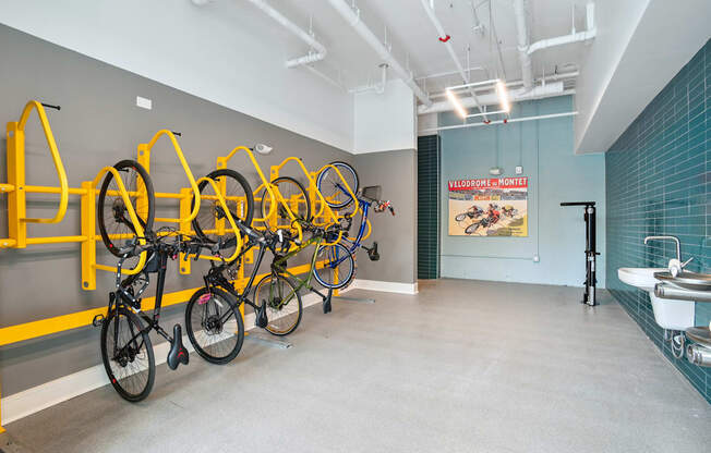 a room with several bikes hanging on a wall and a bathroom with sinks at Link Apartments® Mint Street, North Carolina, 28203