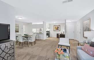a living room and dining area with a television and kitchen in the background
