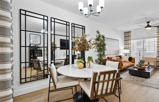 A dining room with a white table and chairs.