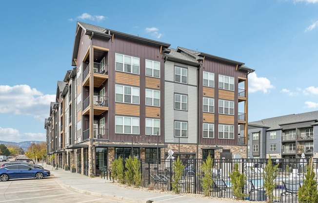 an apartment building with a fence and a parking lot at The Quarry Luxury Apartment Homes, Colorado