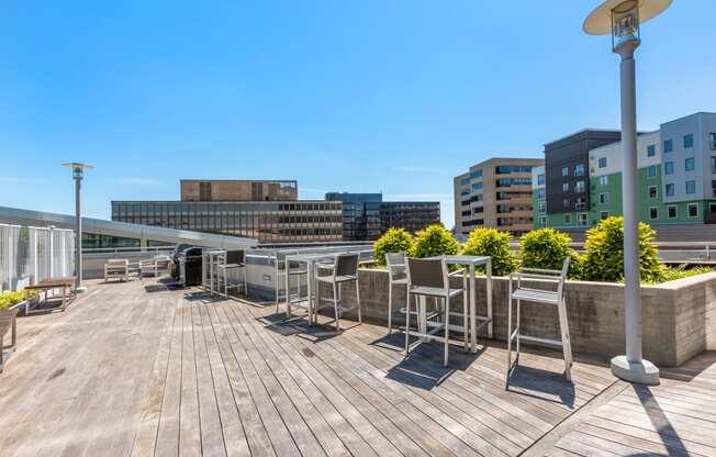 a roof deck with tables and chairs on top of a building