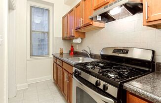 a kitchen with a stove top oven next to a window at the calverton apartments in washington dc