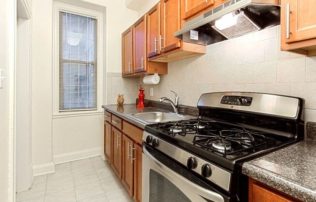 a kitchen with a stove top oven next to a window at the calverton apartments in washington dc