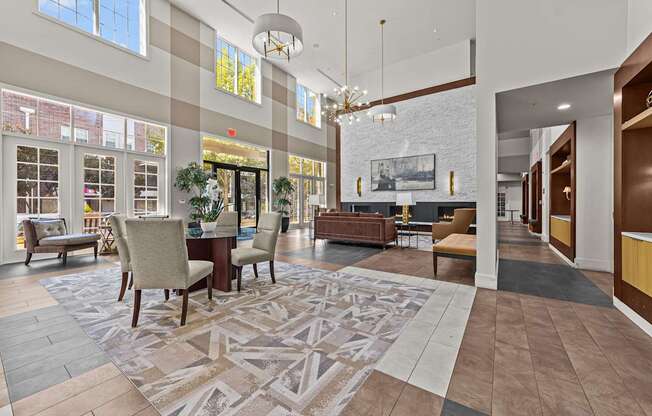 a large lobby with chairs and tables and a fireplace