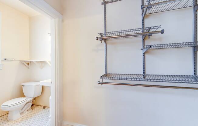 bath room with view of toilet, vanity and custom shelving at 1818 riggs place apartments in washington dc