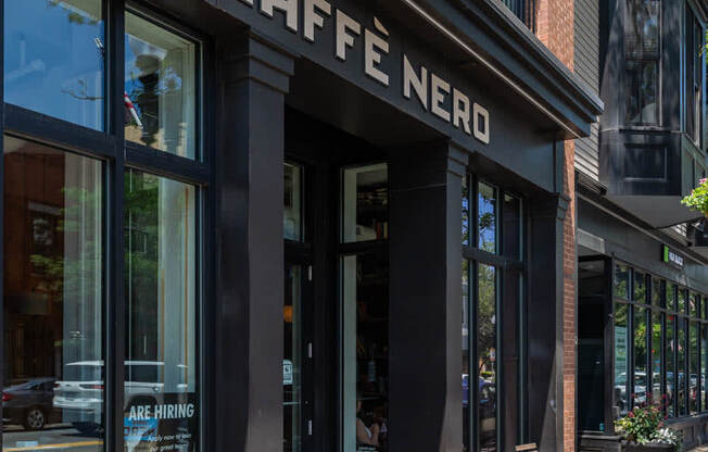 a coffee shop on the corner of a city street "Cafe nero"