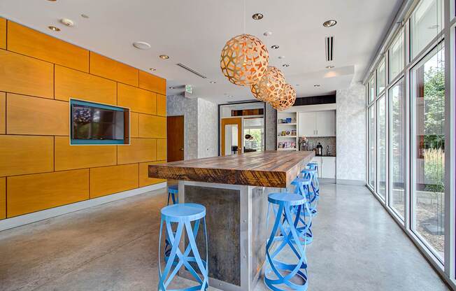 A modern seating area with blue stools and a wooden counter.