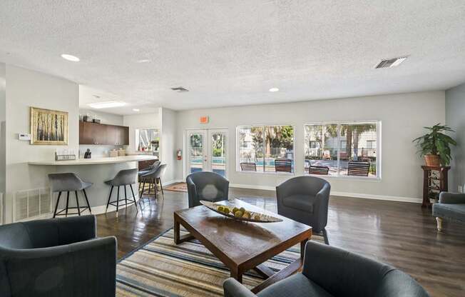A living room with a brown table and grey chairs.