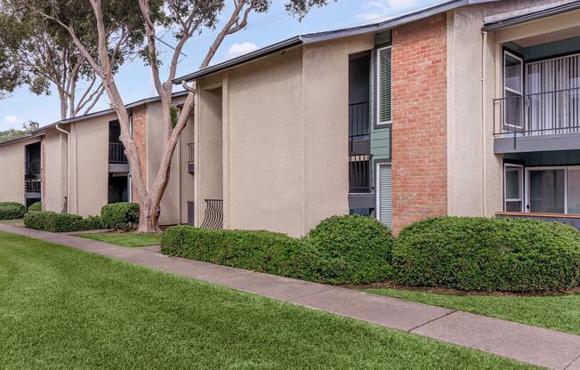 a house with a lawn in front of a brick building