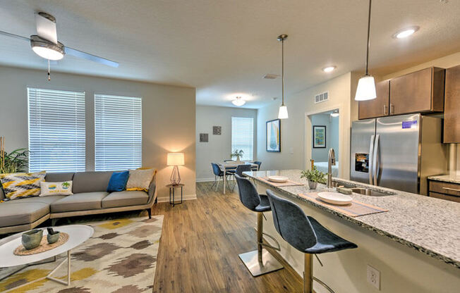 a living room and kitchen area with a couch and a table  at Fusion, Jacksonville, FL