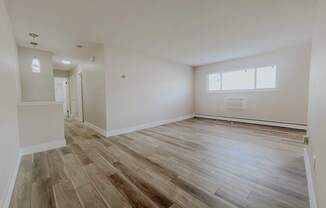 A room with wooden flooring and a window.