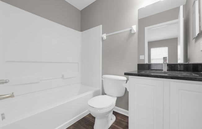 a white bathroom with a toilet and a bath tub at Traditions at Slate Ridge, Ohio, 43068
