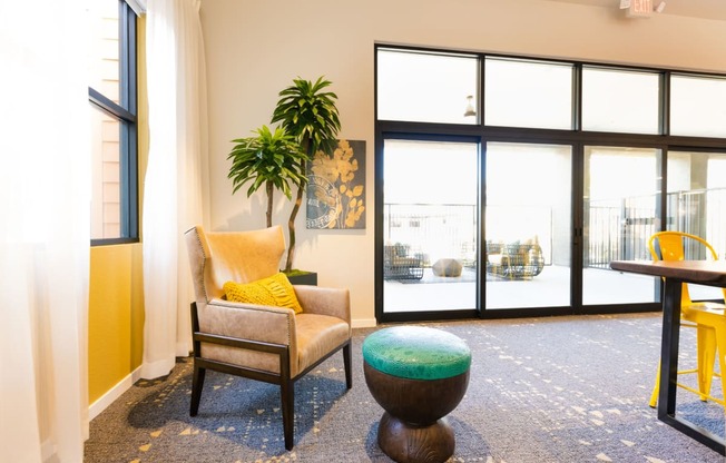 a living room with a chair and a table in front of a window