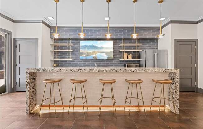 A kitchen with a bar area featuring a granite counter and bar stools.