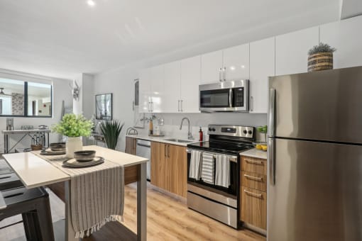 A kitchen with stainless steel appliances and a dining table at Bay Village 1 Apartment in Palmetto Bay, FL