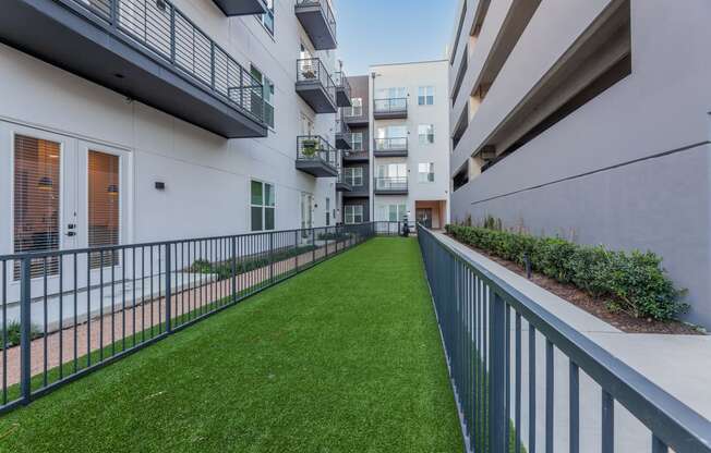 a grassy area on the balcony of an apartment building