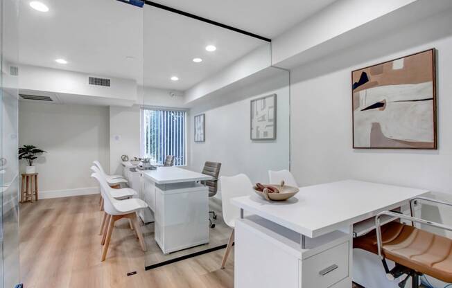 a home office with a desk and chairs and a mirror