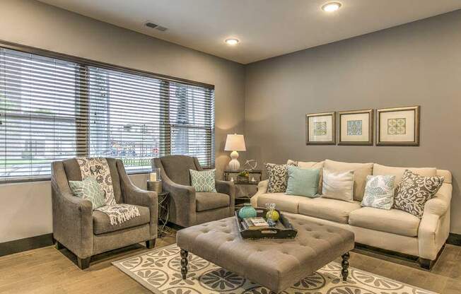 Furnished open floor plan living room with large windows for natural light at The Helen