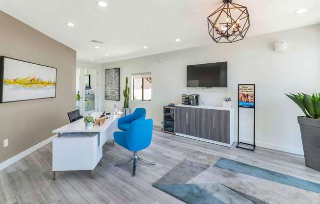 a living room with a desk and a chair and a tv