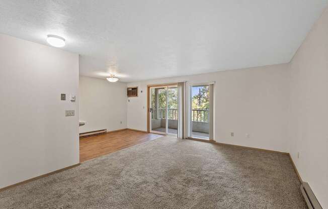 an empty living room with a sliding glass door to a patio