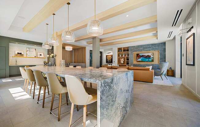 Entertaining space with a dramatic stone island, chic pendant lighting, and seamless flow into lounge seating