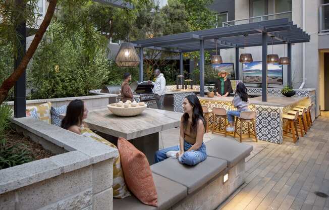 a group of people sitting on benches in an outdoor patio