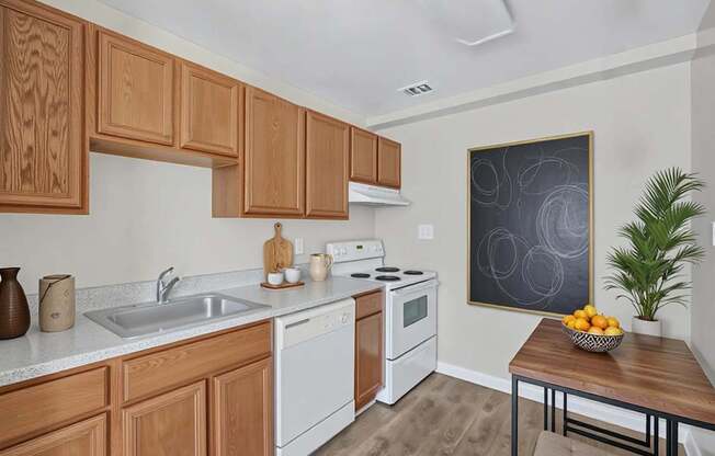 A kitchen with wooden cabinets and a white dishwasher at Highland Ridge Apartments, Capitol Heights