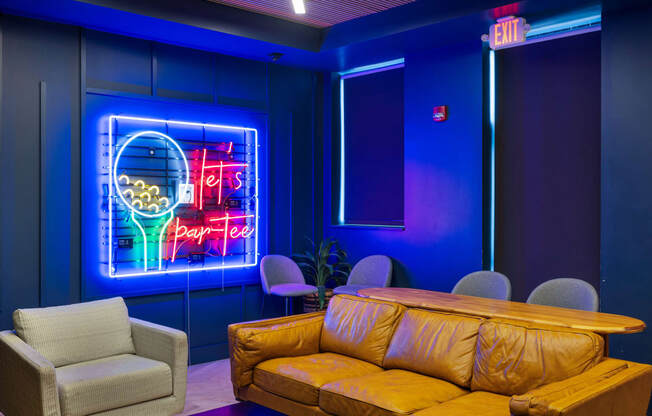 a room with a couch and chairs and a neon sign at EagleRidge Plaza Residences, Fargo, ND