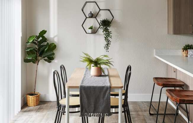 a dining area with a wooden table and black and white chairs