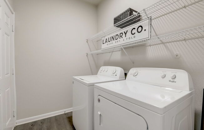 A laundry room with a sign that says