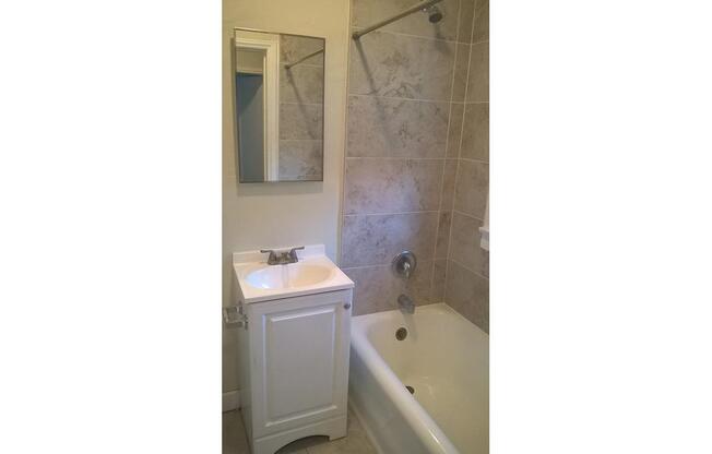 a white sink sitting next to a shower