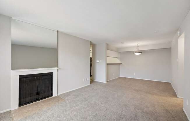 the living room and dining room of an empty home with a fireplace