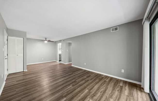 an empty living room with wood floors and grey walls