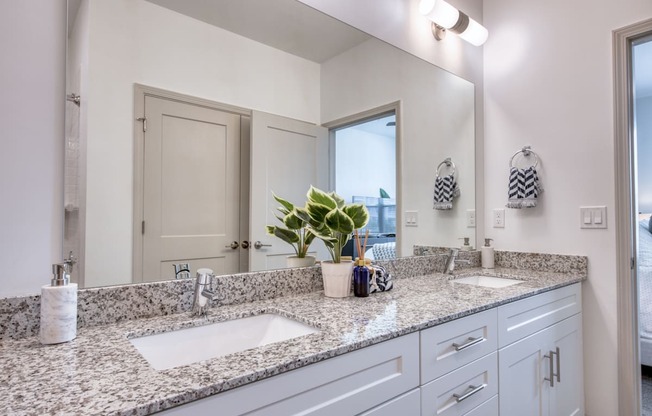 a bathroom with two sinks and a large mirror