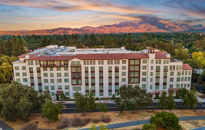 Twilight aerial highlighting elegant architecture and panoramic mountain views in a serene suburban setting