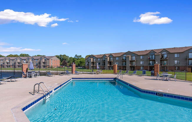A swimming pool in front of apartment buildings at Oak Shores Apartments in Oak Creek, WI
