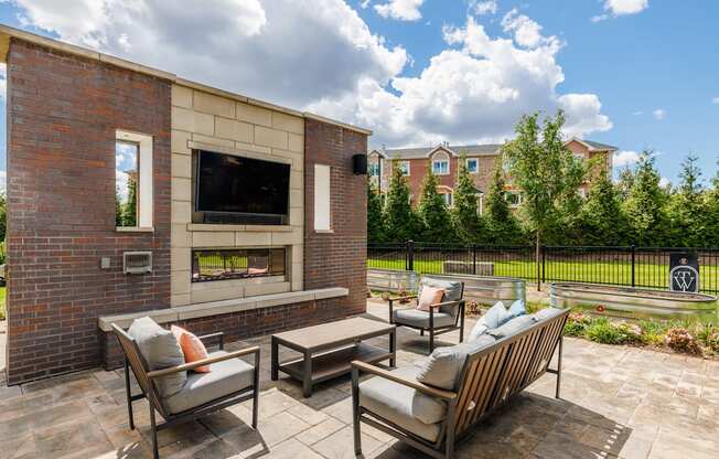 A patio with a brick wall and a television.