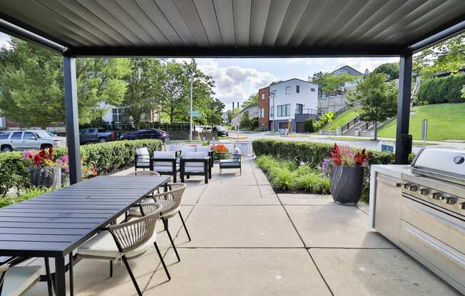 a patio with a table and chairs and a grill