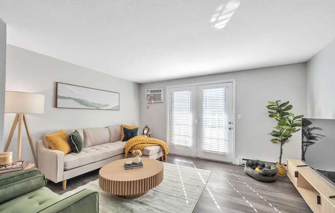 A living room with a sofa, a coffee table, and a green armchair.