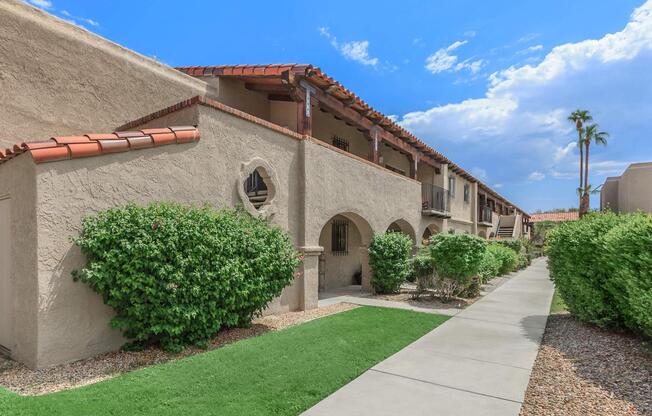 a large brick building with grass in front of a house