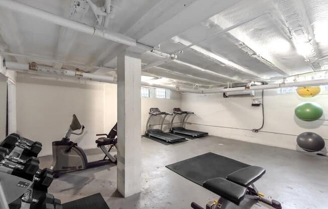 A gym with weights and a treadmill