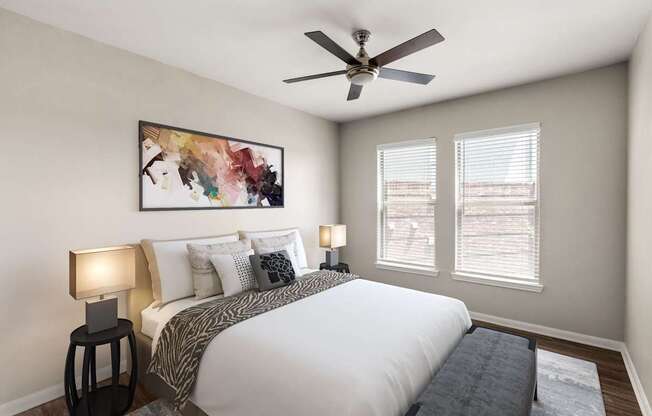 A bedroom with a large bed, two lamps, and a painting on the wall.