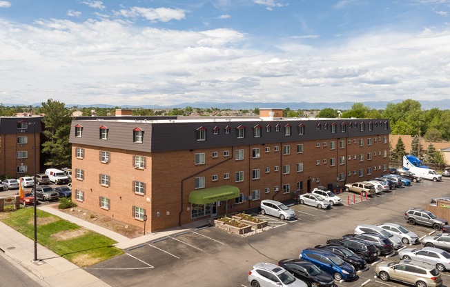 an aerial view of a building with a parking lot full of cars