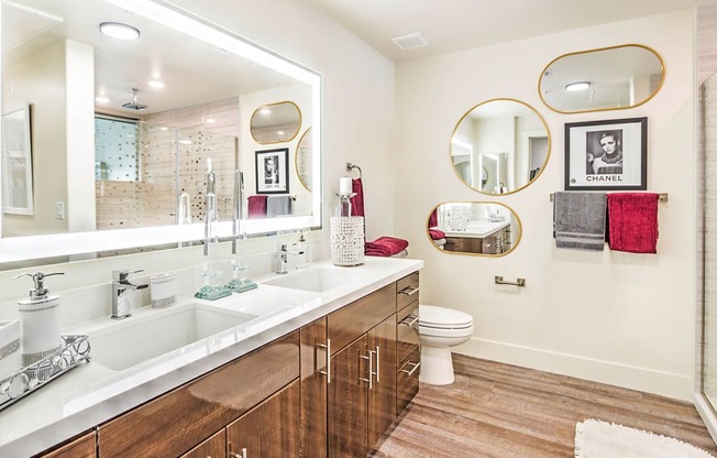 a bathroom with a large mirror and a sink and a toilet