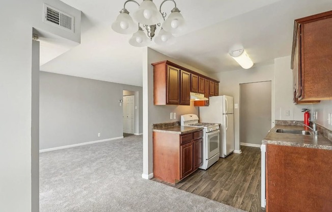 A kitchen with brown cabinets and white appliances.