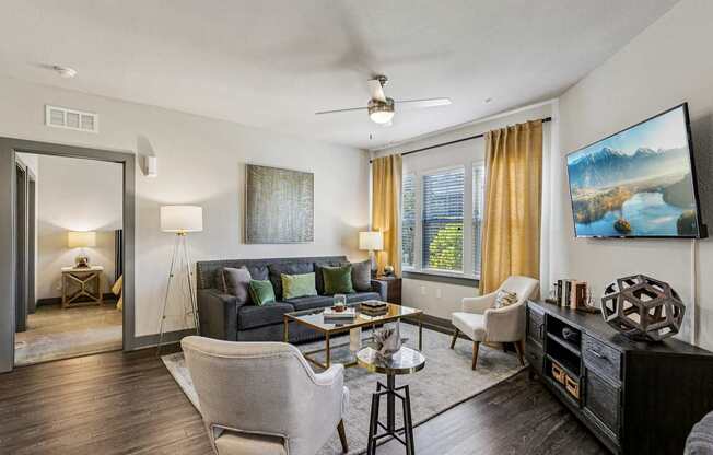 Open living room with ceiling fan, natural light, and comfortable seating at Lotus at Starkey Ranch in Odessa, Florida.