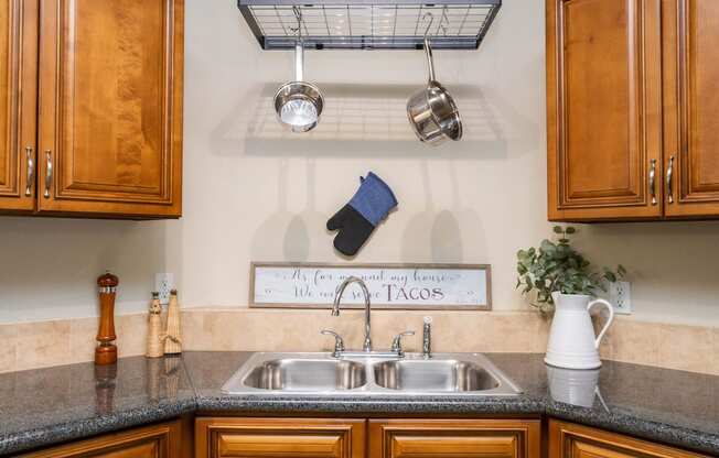 a kitchen with a sink and cabinets and a pot rack above it