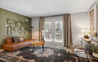 A living room with a brown leather sofa, a coffee table, and a rug.