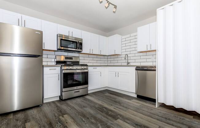 a kitchen with white cabinets and stainless steel appliances