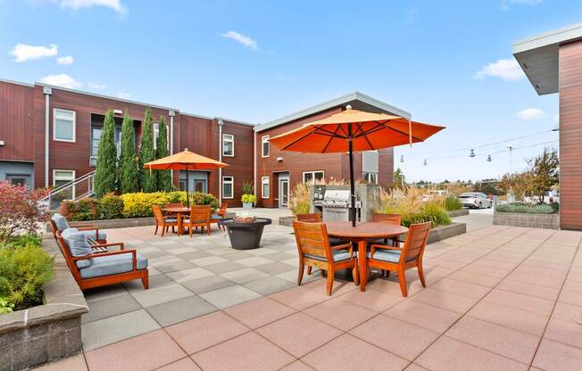 A patio with a table and chairs and an umbrella.
